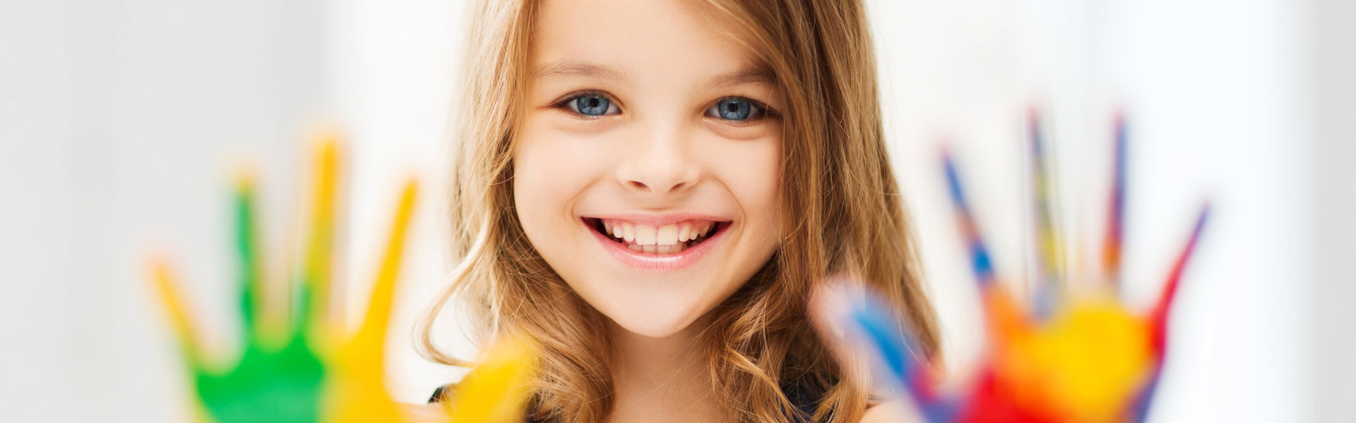 little girl with paint on her hands smile on the camera