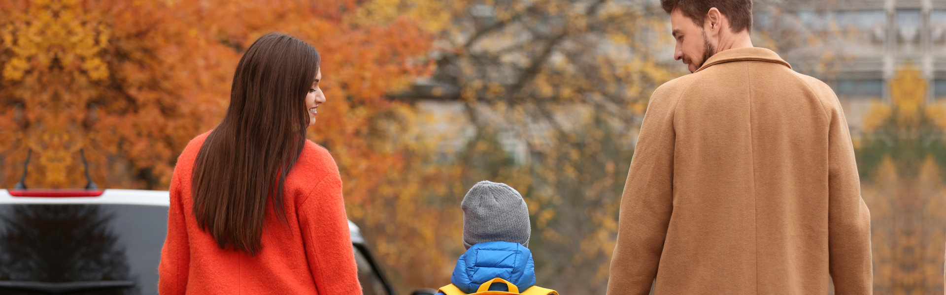 Cute little boy going to school with his parents